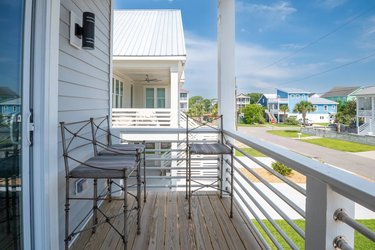 A spacious balcony featuring comfortable seating and a view of surrounding homes, inviting guests to relax, socialize, or simply enjoy the fresh air after a day spent exploring nearby trails and beaches.